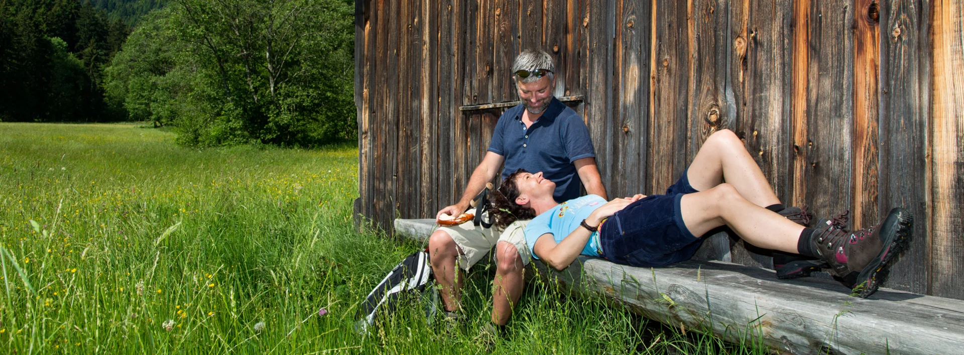 Wanderer auf einer Sitzbank vor einer Hütte im Achtal.