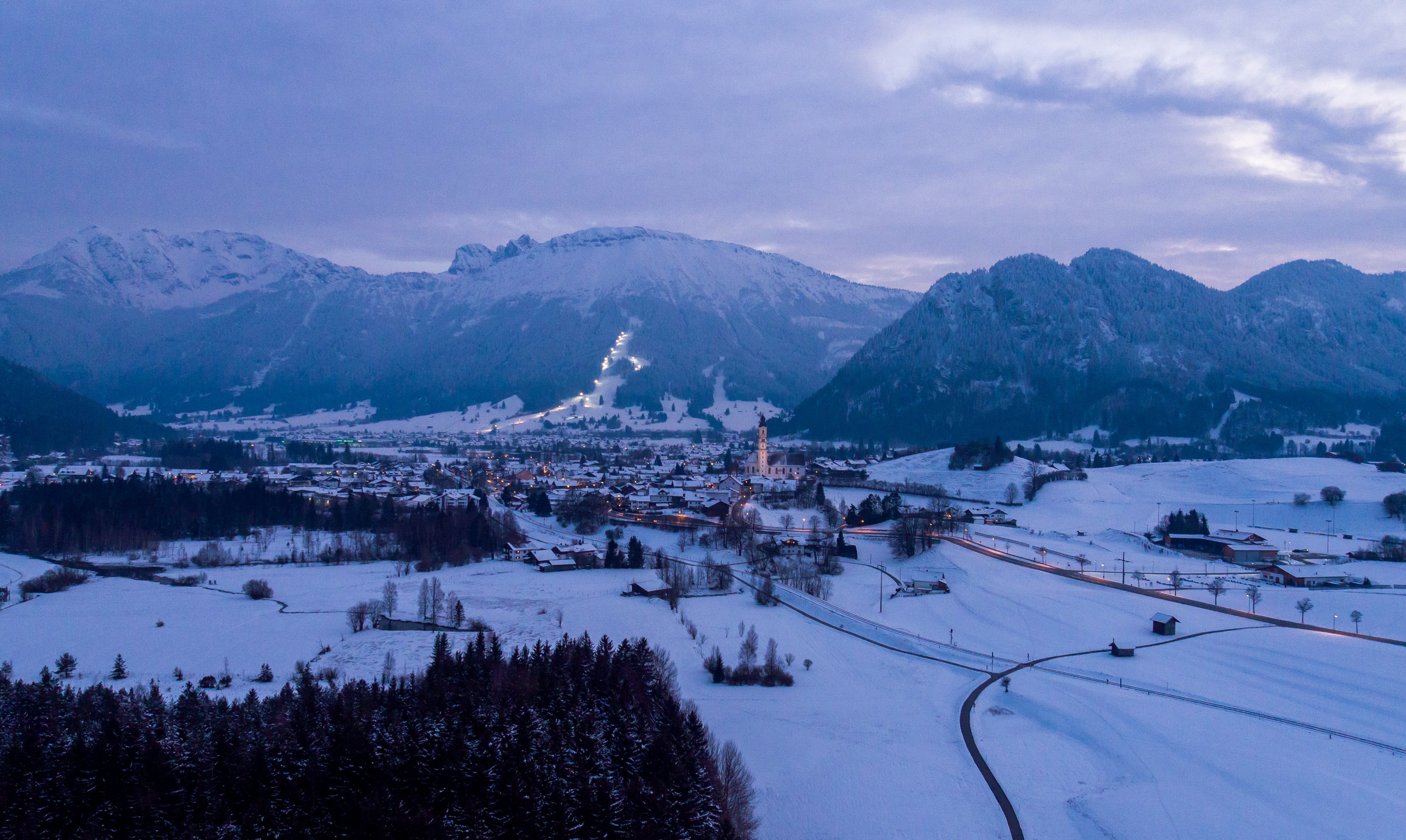 Idyllische Atmosphäre bei eintretender Dunkelheit im verschneiten Pfronten.