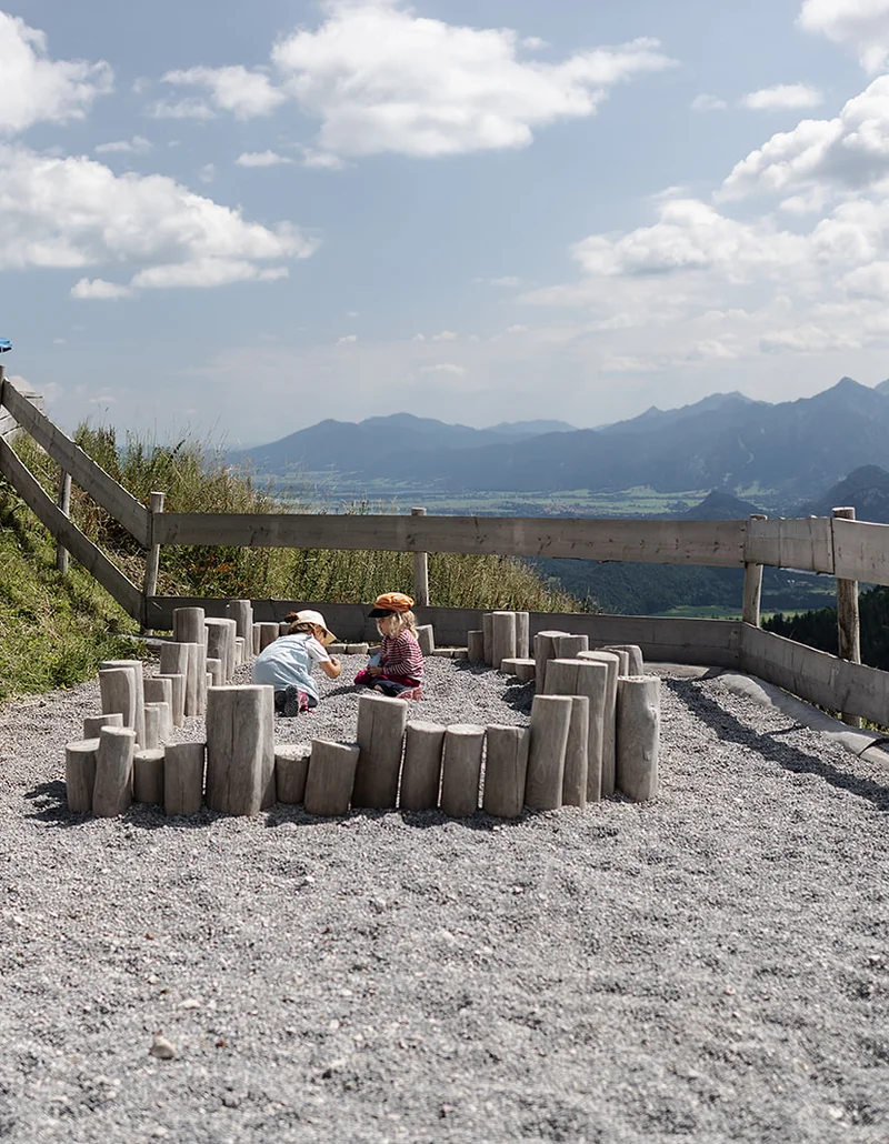 Zwei Mädchen spielen im Kies.