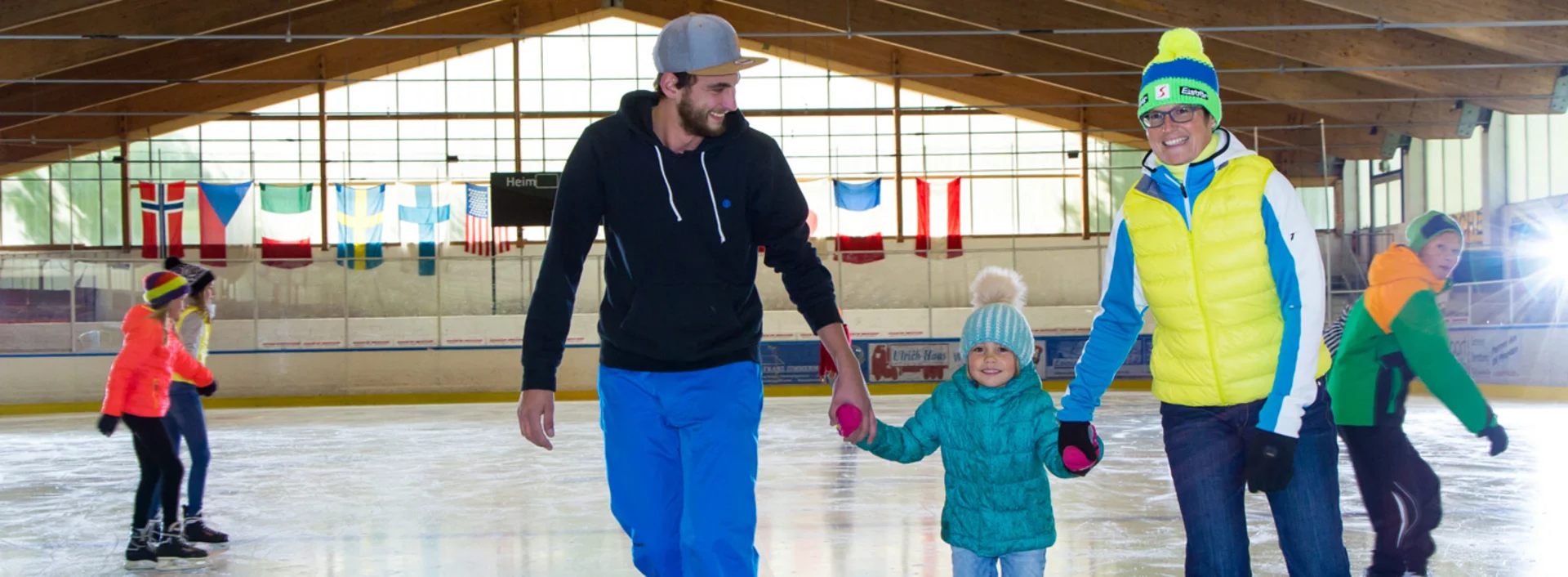Eine Familie beim Eislaufen in der Eishalle in Pfronten.