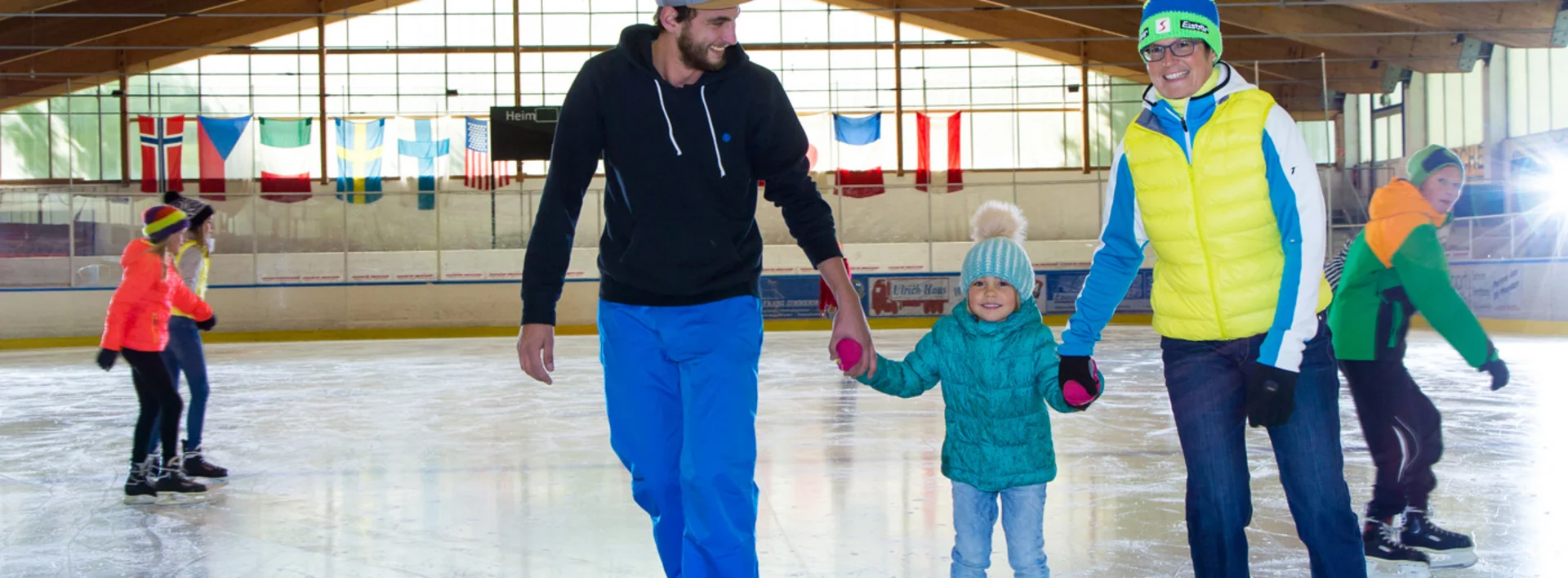 Eine Familie beim Eislaufen in der Eishalle in Pfronten.