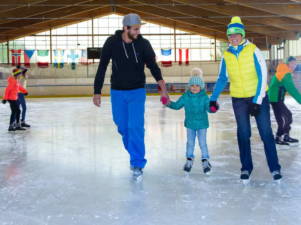 Eine Familie beim Eislaufen in der Eishalle in Pfronten.