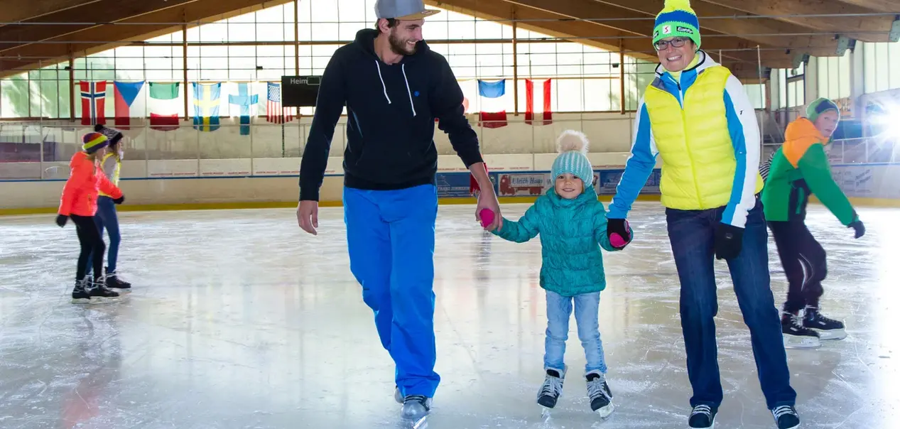Eine Familie beim Eislaufen in der Eishalle in Pfronten.