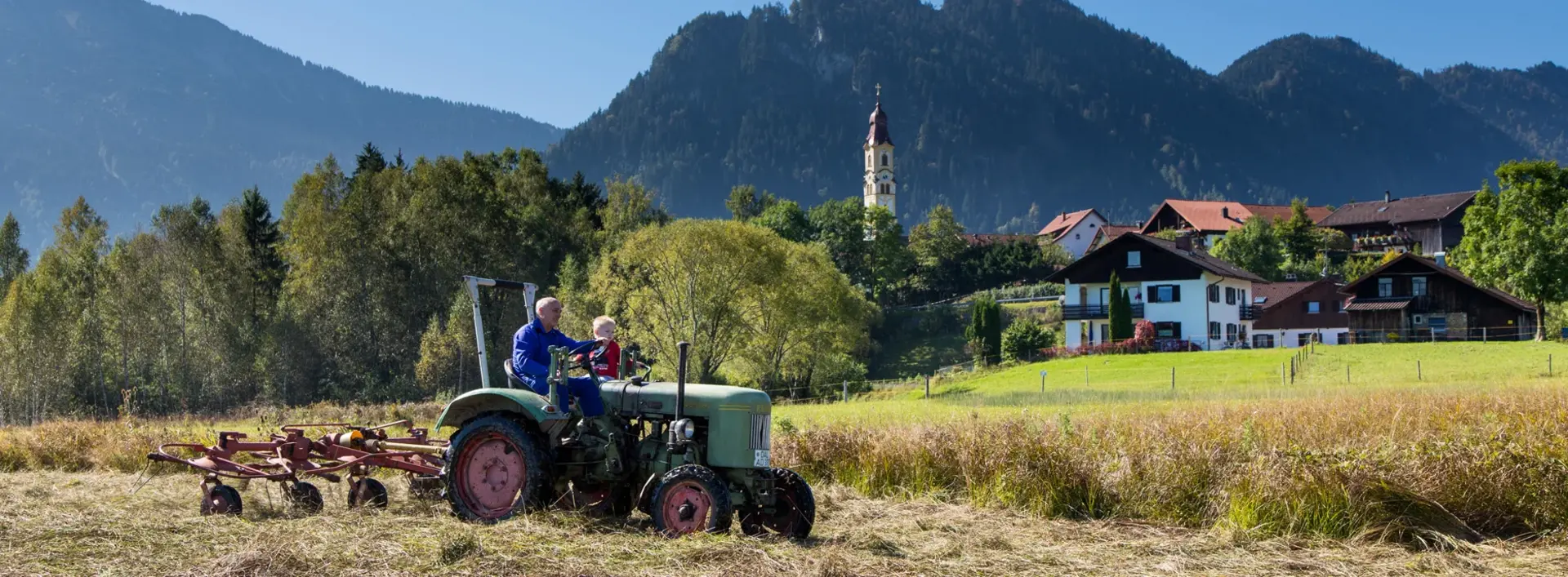 Ein Traktor auf einer Wiese im Pfrontener Tal.