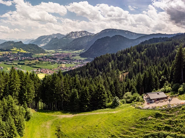 Sommerlicher Panoramablick auf das Pfrontener Tal und eine überwältigende Bergkulisse.