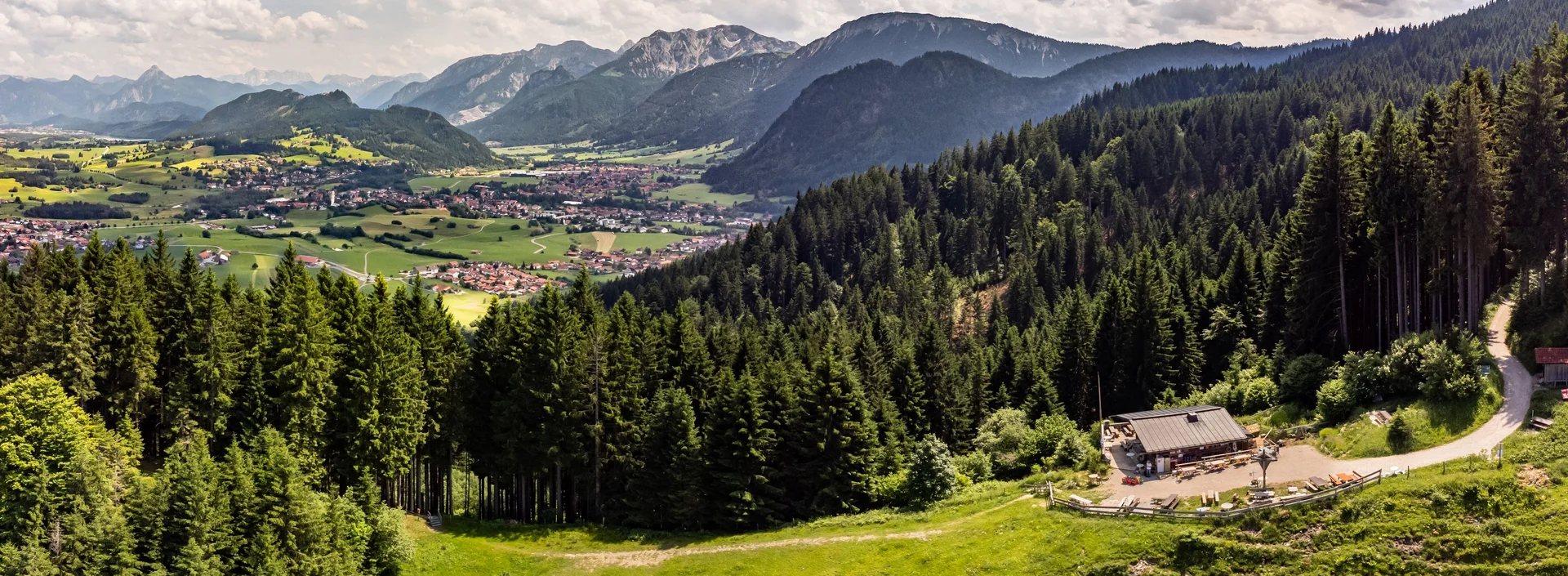 Sommerlicher Panoramablick auf das Pfrontener Tal und eine überwältigende Bergkulisse.
