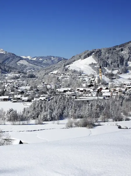 Winterurlaub in Pfronten im Allgäu Panoramablick über das verschneite Pfrontener Tal mit beeindruckender Bergkulisse.