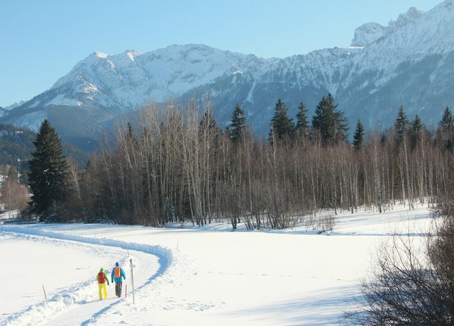 Winterwanderer in einer zauberhaften Schneelandschaft im Pfrontener Tal inmitten der verschneiten Bergwelt.