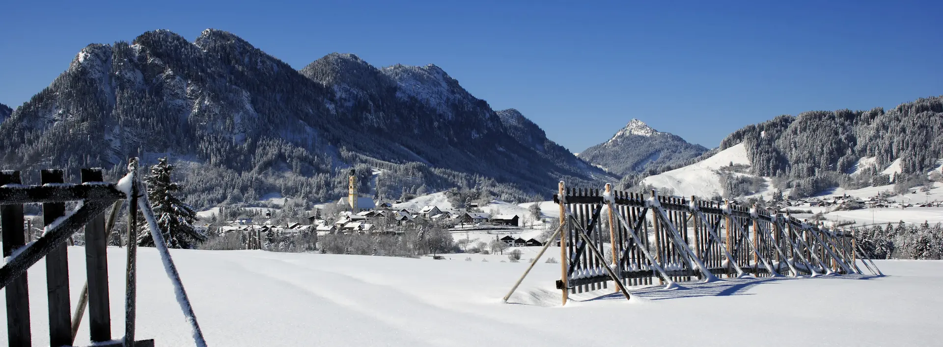 Das verschneite Pfrontener Tal mit Sonnenschein.