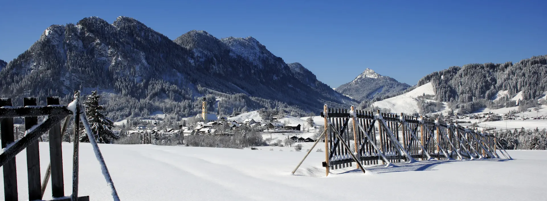 Das verschneite Pfrontener Tal mit Sonnenschein.