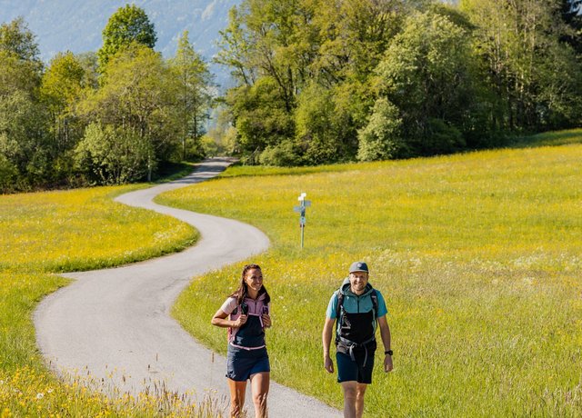 Wanderer im Tal mit Bergen im Hintergrund