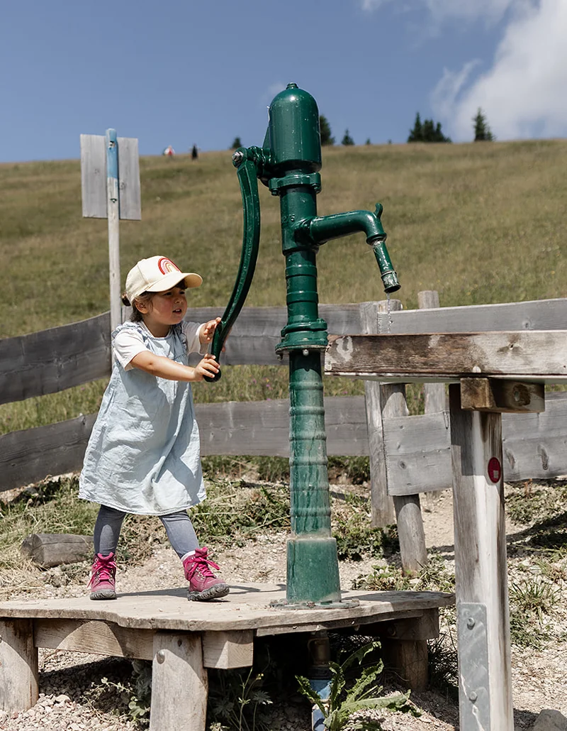 Ein Mädchen spielt auf dem Wasserspielplatz.