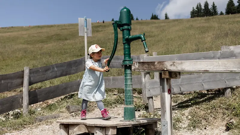 Ein Mädchen spielt auf dem Wasserspielplatz.