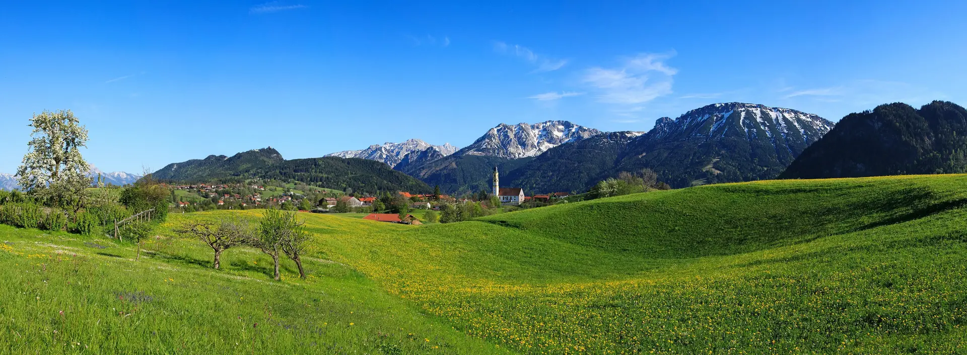 Frühling im Tal und letzte Schneereste auf den Gipfeln der Allgäuer Alpen 