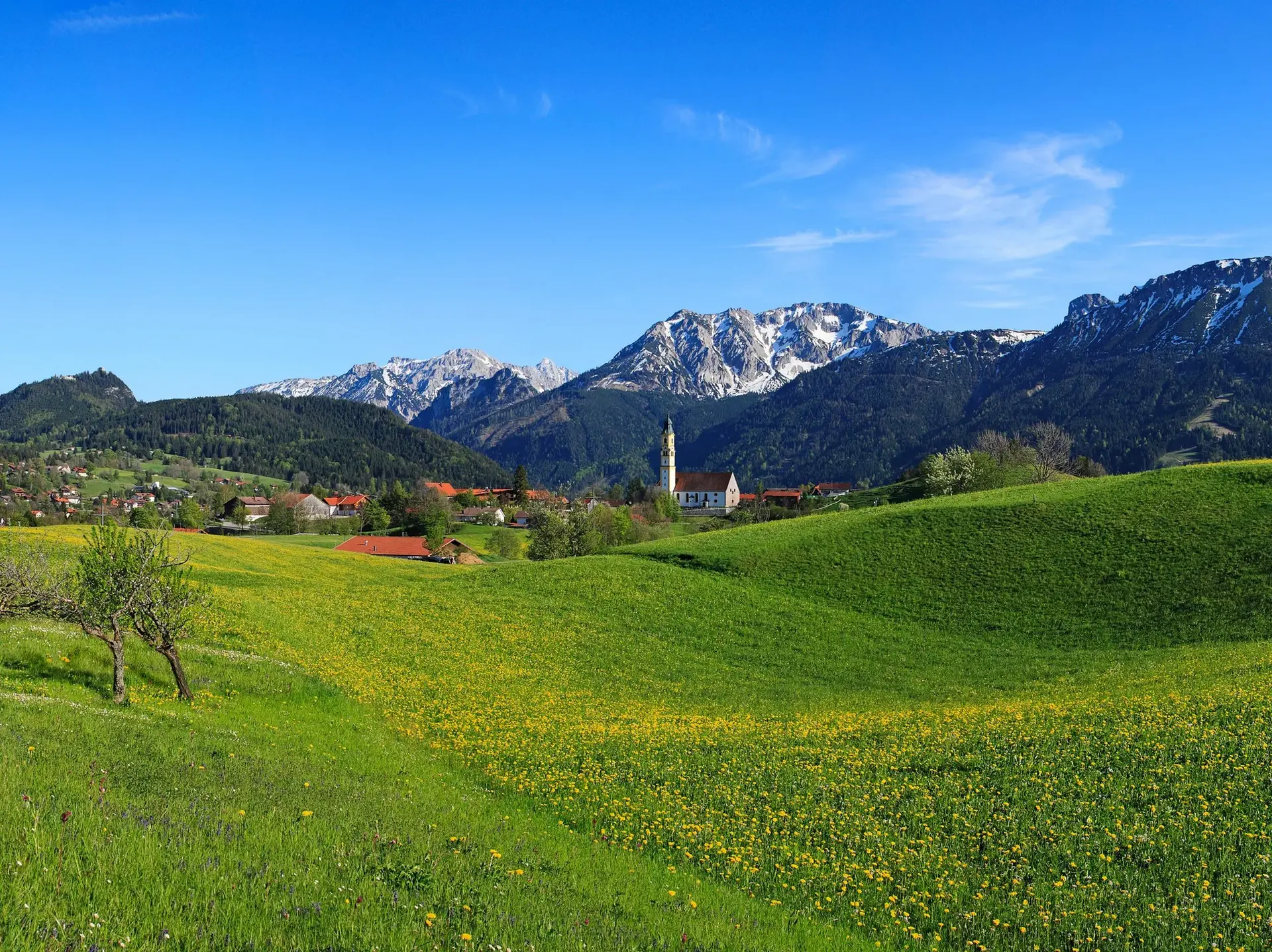 Frühling im Tal und letzte Schneereste auf den Gipfeln der Allgäuer Alpen 