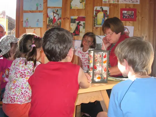 Eine Gruppe Kinder sitzt um einen Tisch bei einer Märchen- und Malstunde.