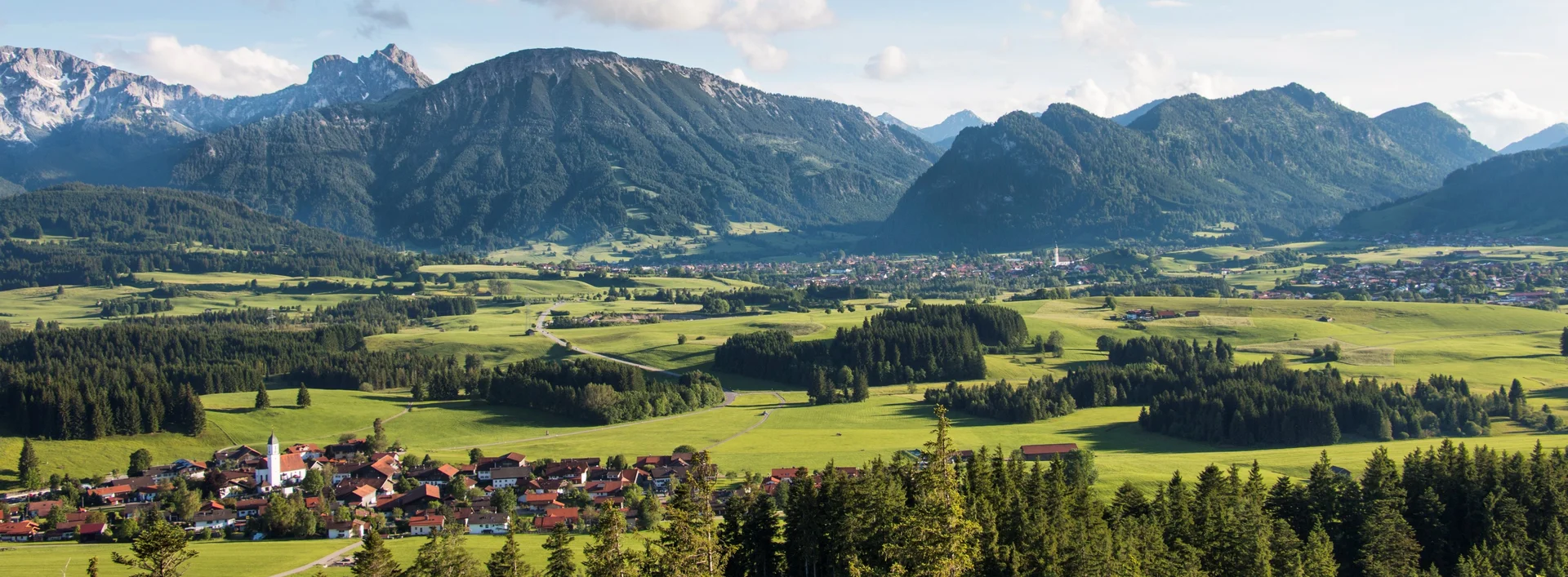 Eindrucksvoller Panoramablick auf das sonnige Tal mit schöner Bergkulisse.