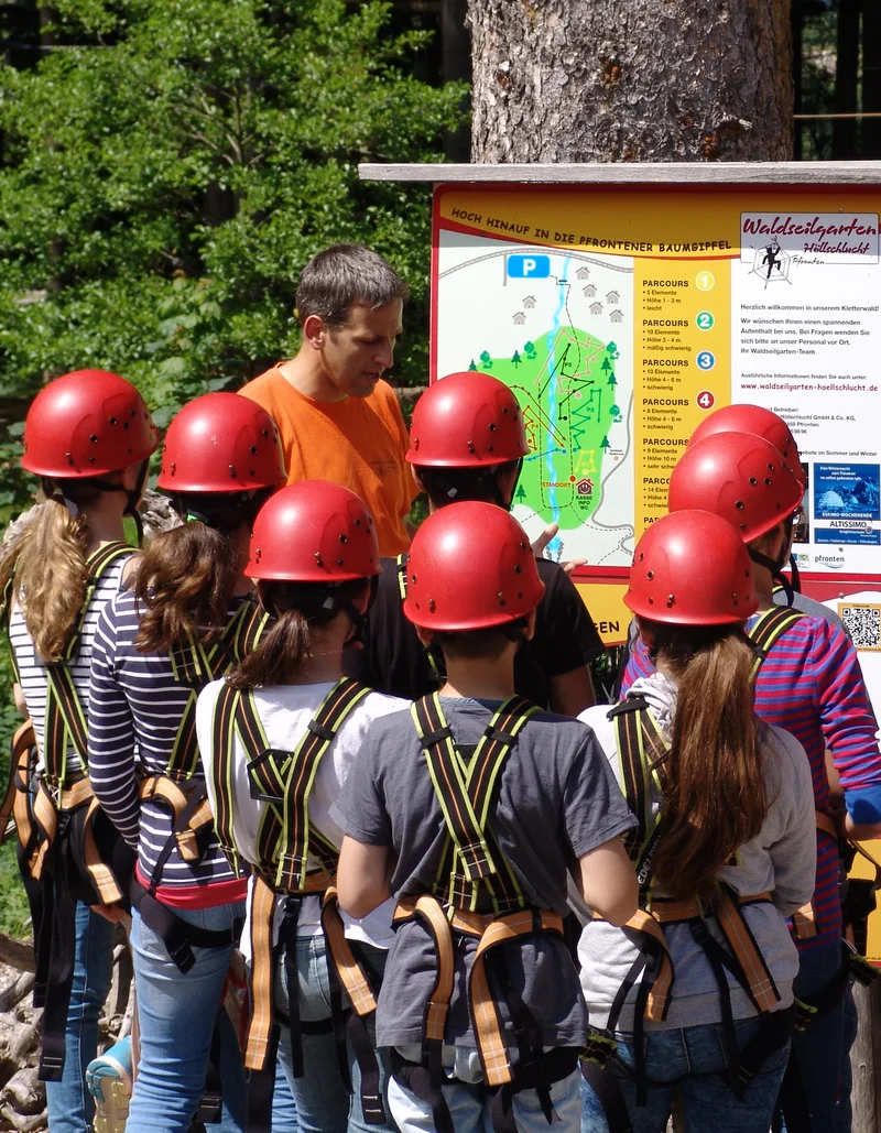 Eine Gruppe Kletterer im Waldseilgarten in Pfronten.