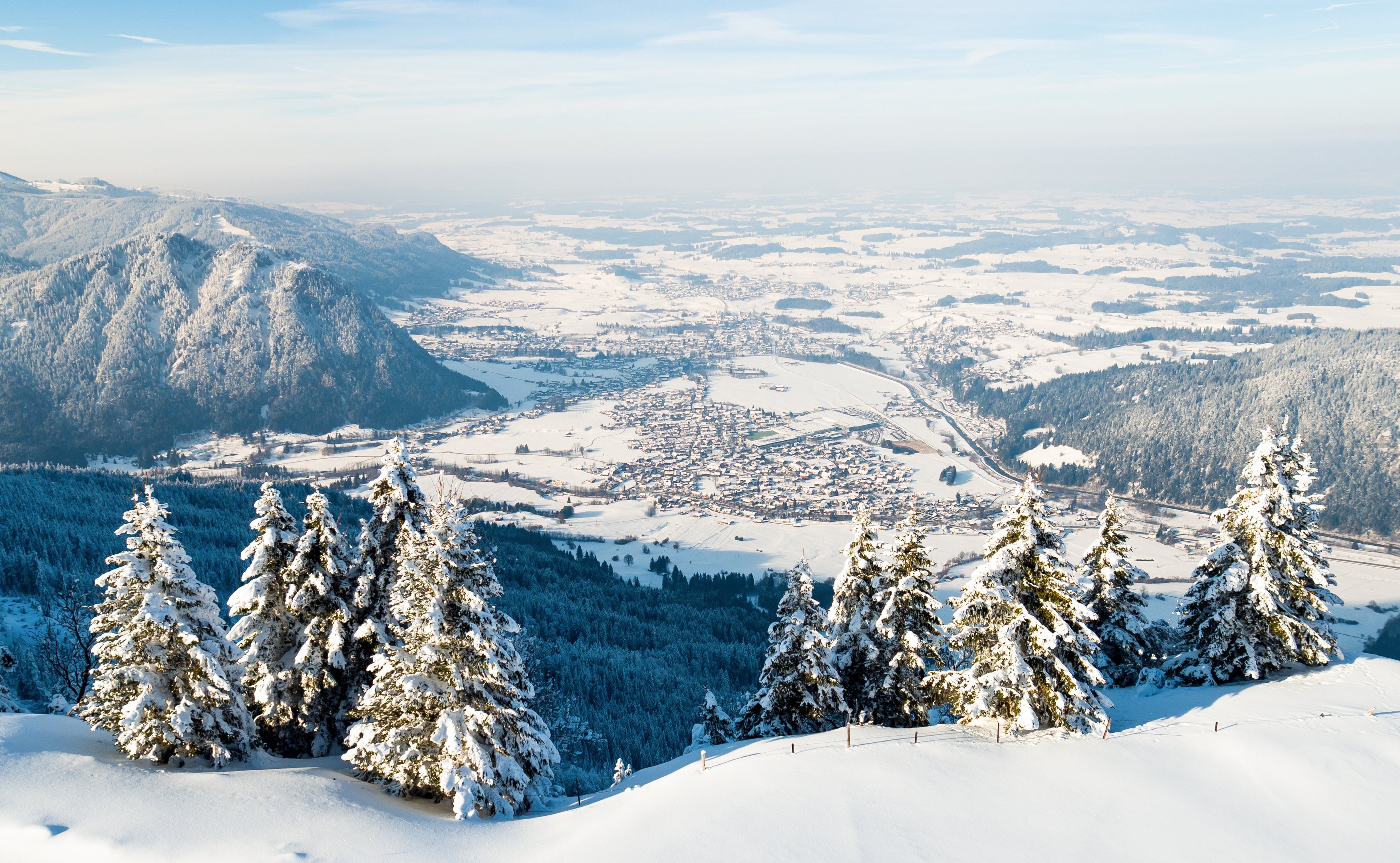 Winterlicher Panoramablick auf das verschneite Pfrontener Tal und die umliegende Berglandschaft.