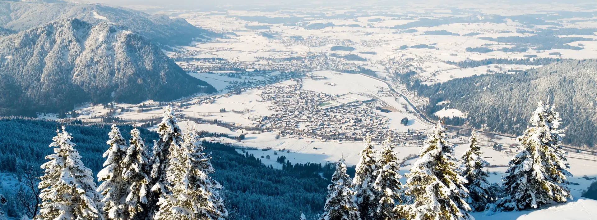 Winterlicher Panoramablick auf das verschneite Pfrontener Tal und die umliegende Berglandschaft.