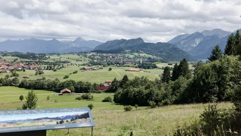Panoramablick auf Pfronten mit Bergen im Hintergrund.