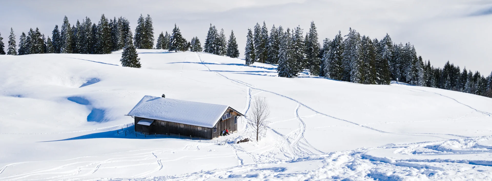 Eine idyllisch verschneite Bergkulisse bei Sonnenschein.