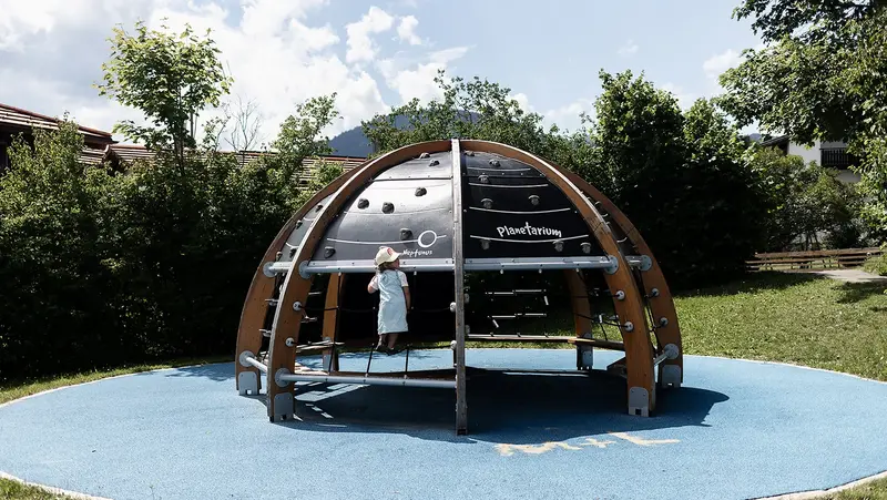 Ein Mädchen spielt auf einem Kuppel-Spielgerät.
