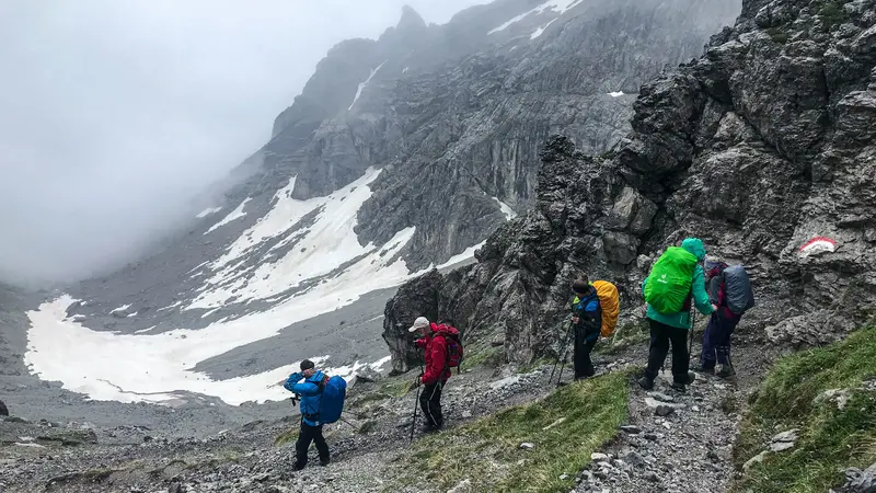 Wanderer auf abenteuerlichen Pfaden in alpiner Kulisse.