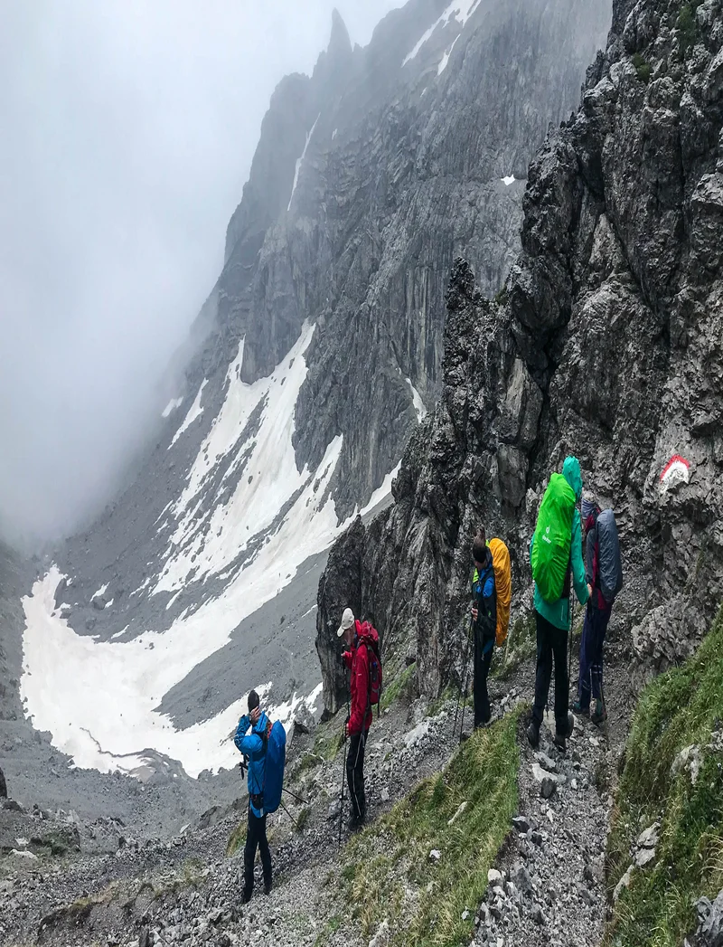 Wanderer auf abenteuerlichen Pfaden in alpiner Kulisse.