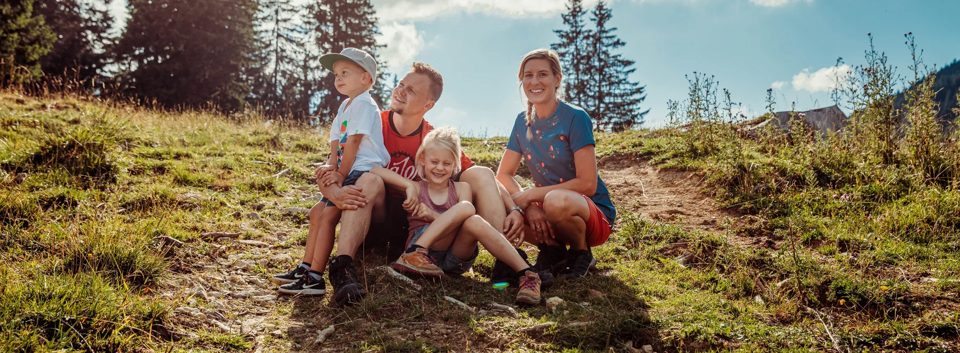 Eine Familie auf einer sonnigen Bergwiese.