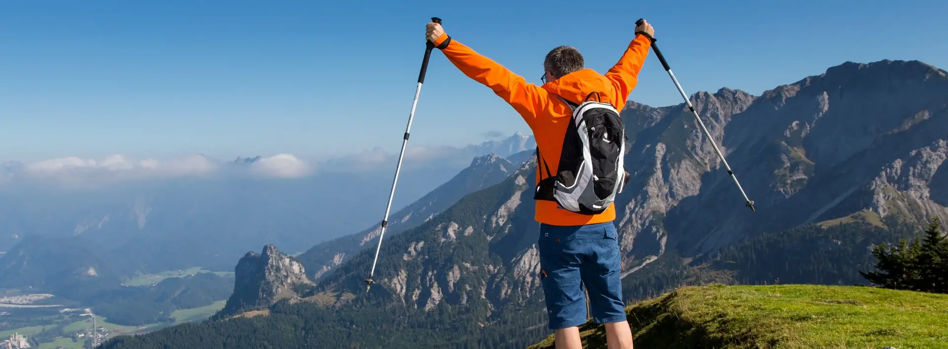 Ein Wanderer steht vor einer beeindruckenden Bergkulisse.
