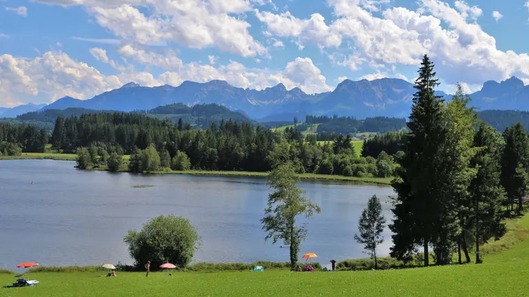 Der Schwaltenweiher mit großer Liegewiese und tollem Bergpanorama.
