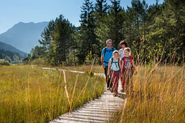 Eine Familie geht spazieren auf dem Moorpfad in Pfronten im Allgäu.