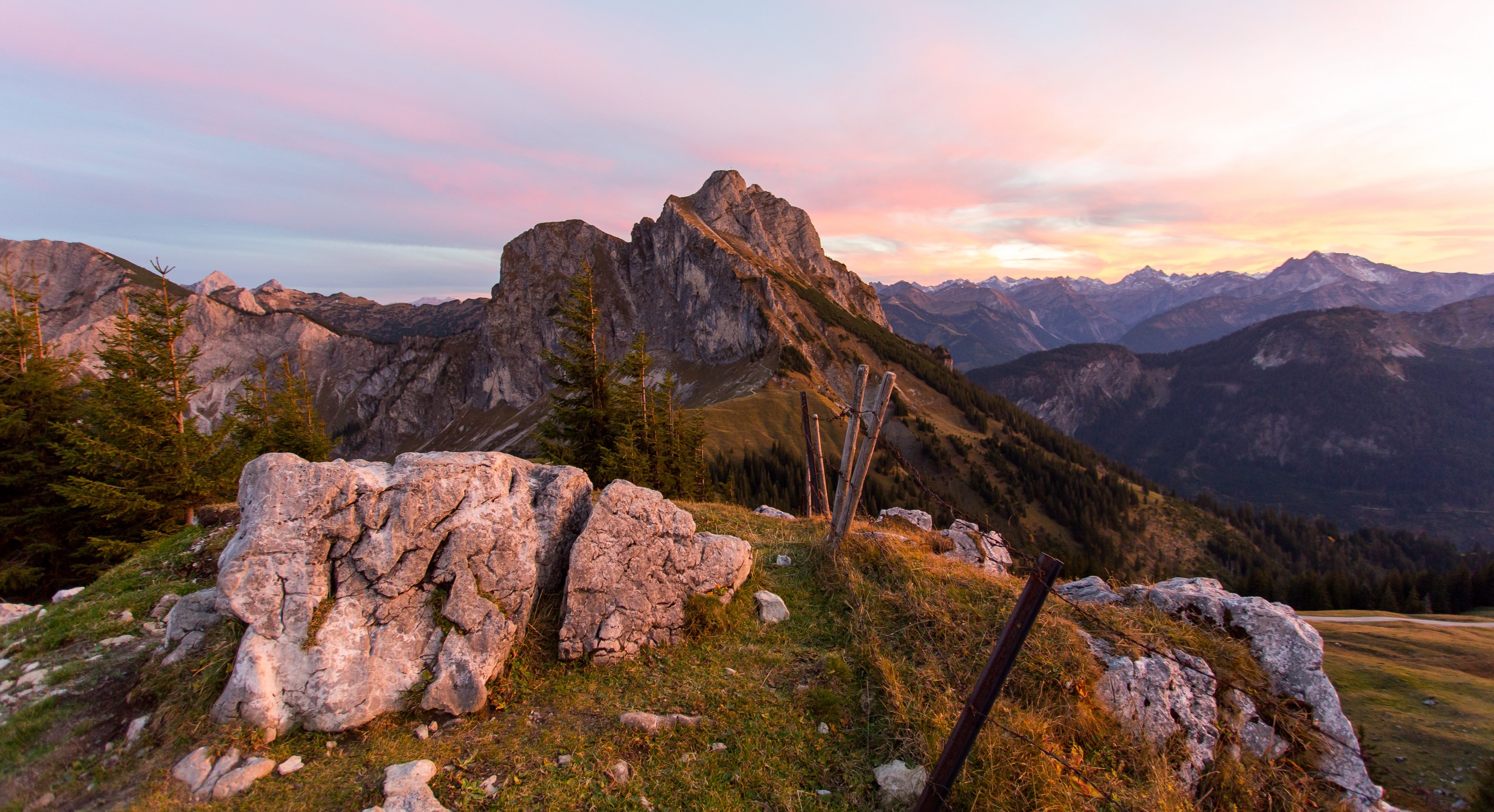 Weiter Panoramablick auf die beeindruckende Bergkulisse bei einem magischen Farbenspiel der Sonne.