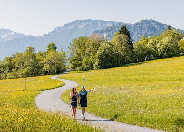 Wanderer im Tal mit Bergen im Hintergrund