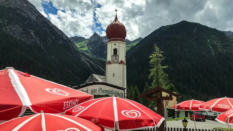 Ein Biergarten mit toller Bergkulisse im Hintergrund.