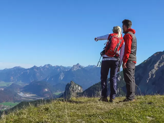 Wanderer genießen die Aussicht auf die beeindruckende Allgäuer Bergkulisse.