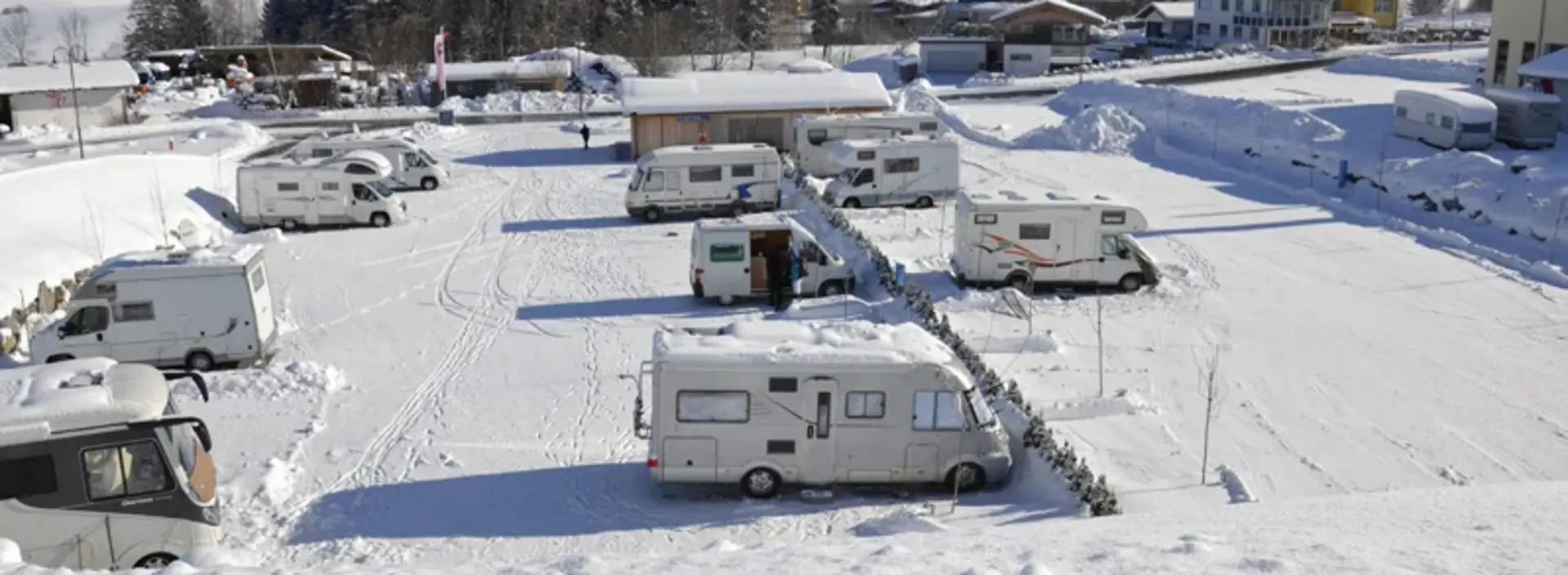 Wohnmobile auf einem Stellplatz in Pfronten im Winter.