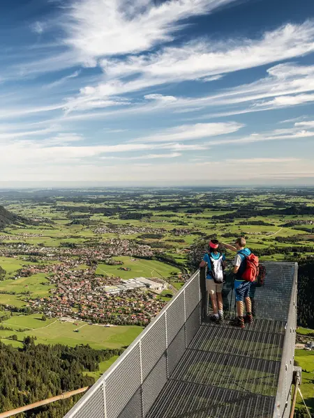 Weitreichender Blick über den Aussichtssteg auf dem Breitenberg auf das Pfrontener Tal und die umliegende Berglandschaft.