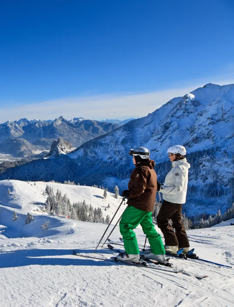 Skifahrer auf der Piste am Breitenberg mit winterlichem Panoramablick und beeindruckender Bergkulisse.