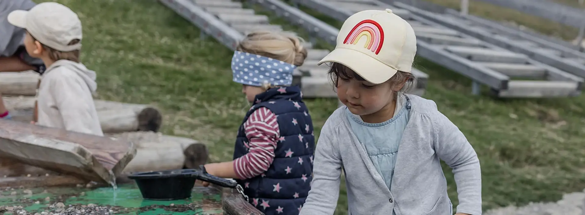 Kinder spielen an einem Wasserspieltisch.