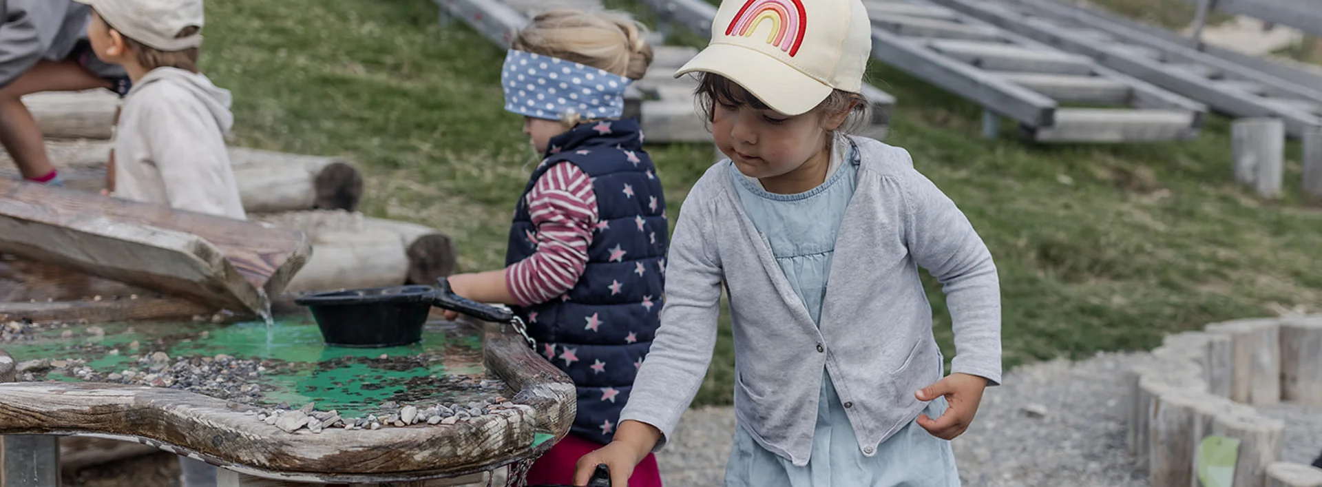 Kinder spielen an einem Wasserspieltisch.