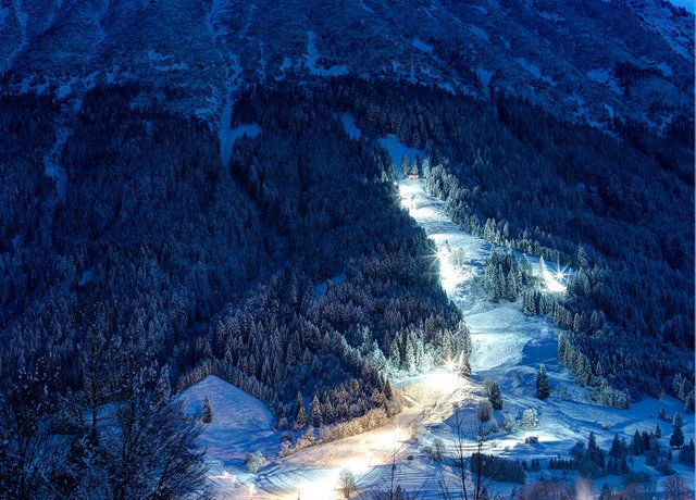 Die erleuchtete Flutlichtpiste strahlt durch die Nacht.