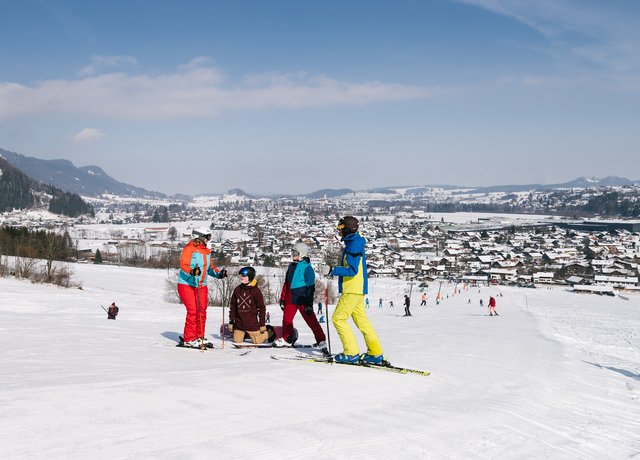 Skifahrer auf der Piste, im Hintergrund ist das verschneite Tal zu erkennen.