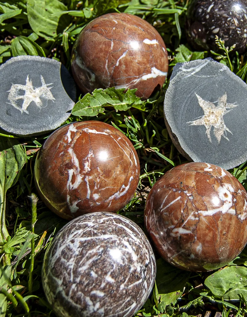 Kugeln aus Stein liegen auf einer grünen Wiese.