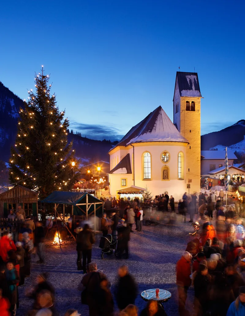 Weihnachtliche Atmosphäre mit schönen Beleuchtungen bei Nacht auf dem Pfrontener Weihnachtsmarkt.