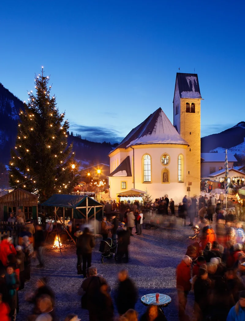 Weihnachtliche Atmosphäre mit schönen Beleuchtungen bei Nacht auf dem Pfrontener Weihnachtsmarkt.