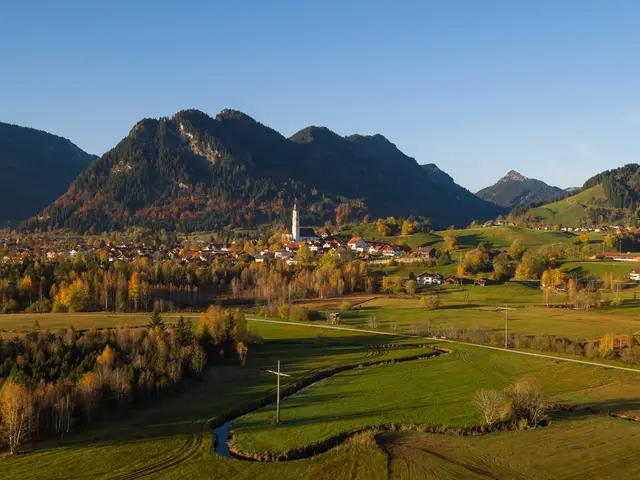 Herbstlicher Blick auf grüne Wiesen in Pfronten und eine sonnigen Berglandschaft.