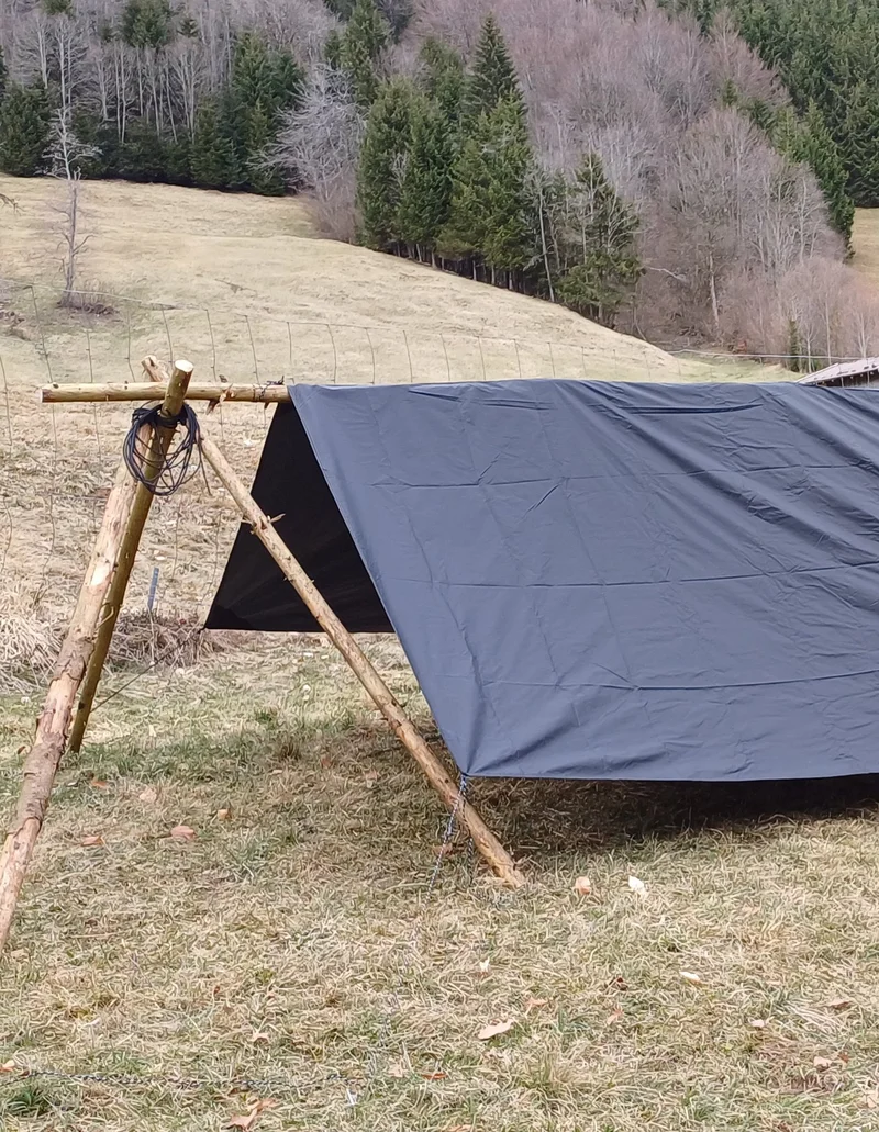 Ein Tab ist mit Holzbalken aufgebaut und demonstriert ein Survivalabenteuer in der Wildnis.