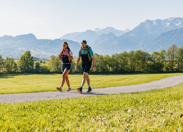 Wanderer im Tal mit Bergen im Hintergrund